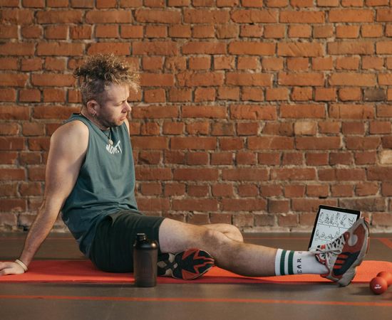 Calm man sitting in nature after workout session